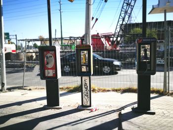 Information sign on pole in city against sky