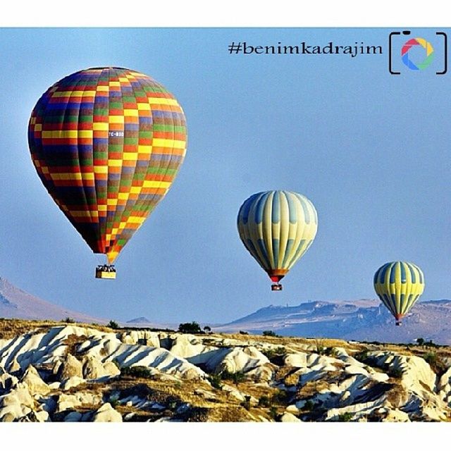 hot air balloon, flying, parachute, mid-air, clear sky, multi colored, copy space, adventure, paragliding, low angle view, transportation, leisure activity, extreme sports, blue, sky, fun, travel, outdoors, parachuting, tourism