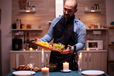 Portrait of senior man preparing food on table