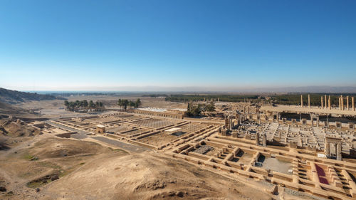 High angle view of buildings against clear blue sky