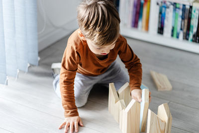 High angle view of boy sitting on floor at home