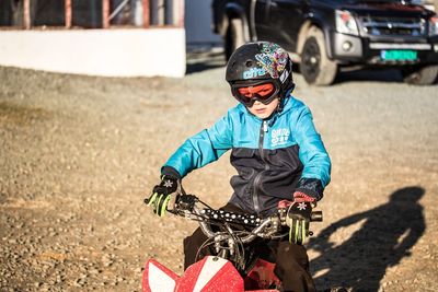 Portrait of boy riding bicycle on road