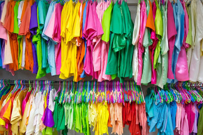 Colorful clothes hanging for sale at market stall