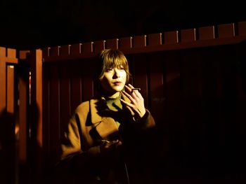 Portrait of boy standing in dark room