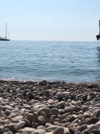 View of pebbles on beach against clear sky