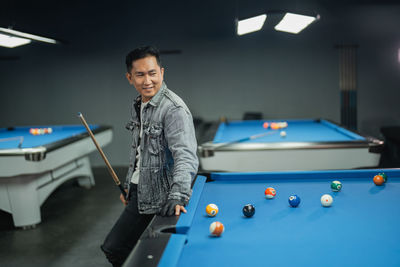 Midsection of man playing pool