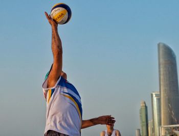 Low angle view of man playing soccer against sky