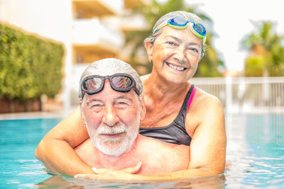 Portrait of smiling senior couple in swimming pool