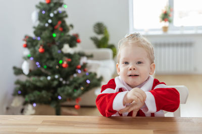 Portrait of cute baby girl sitting on table