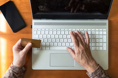 Midsection of person using laptop on table