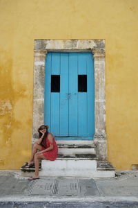 Portrait of woman sitting outside building