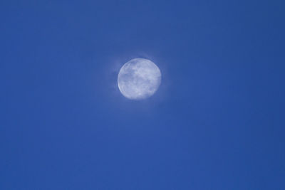 Low angle view of moon against blue sky