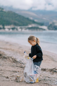 Side view of boy standing at beach