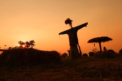 Silhouette trees on field against sky during sunset