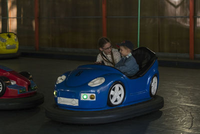 High angle view of boy and girl sitting in bumper car