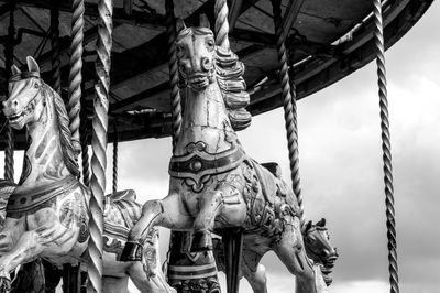 Carousel horses against cloudy sky