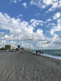 People on beach against sky