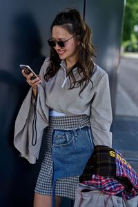 Young woman using mobile phone while standing outdoors