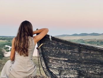 Rear view of woman against sky during sunset