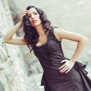 Young woman standing by wall