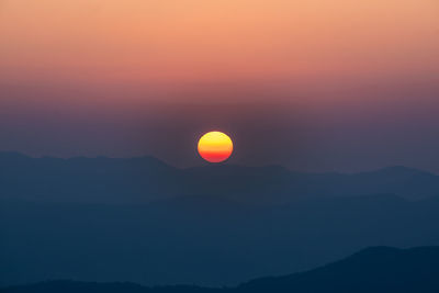 Scenic view of silhouette mountains against romantic sky at sunset