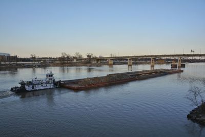 Boats in river against clear sky