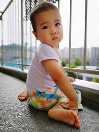 Portrait of cute baby girl sitting in balcony