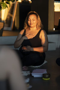 Woman with hand on chest meditating at retreat center