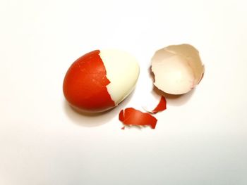 Close-up of broken egg over white background