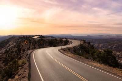 Empty road against sky during sunset