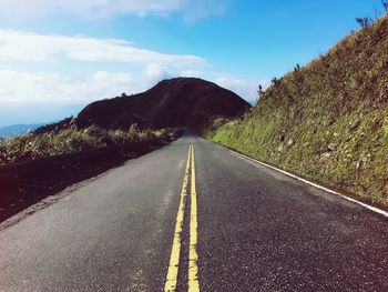 Road amidst mountains against sky