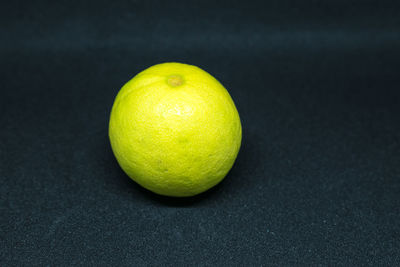 Close-up of lemon on table against black background