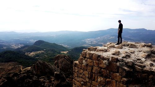 Man standing on mountain against sky