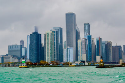 Skyscrapers in city against cloudy sky