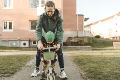 Mother helping daughter to cycle