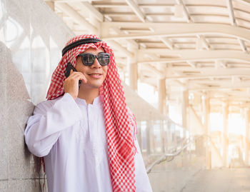 Portrait of young woman wearing sunglasses standing outdoors