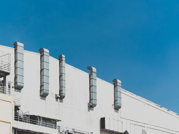 Low angle view of buildings against clear blue sky