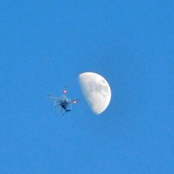 Low angle view of airplane against blue sky