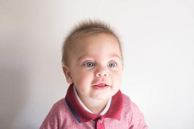 Cute boy looking away against white background