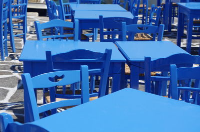 Empty chairs and table against blue sky