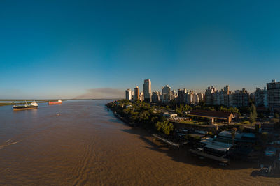 Panoramic view of sea and buildings against clear blue sky