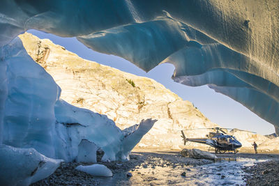 Helicopter parked next to glacier in the coast mountains.