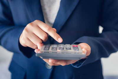 Midsection of man holding mobile phone