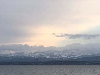 Scenic view of sea and mountains against sky