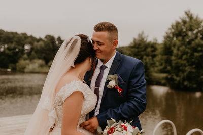 Portrait of smiling couple standing against trees