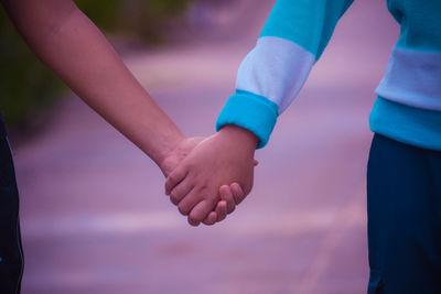 Close-up of friends holding hands