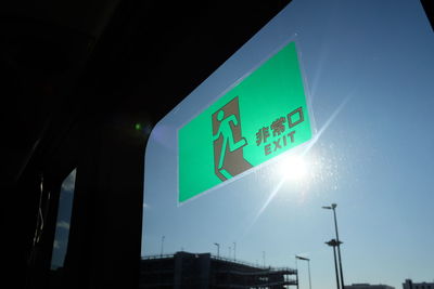 Low angle view of illuminated sign against clear sky at night