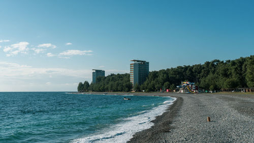 Scenic view of sea by buildings against sky