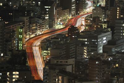 High angle view of illuminated street amidst buildings at night