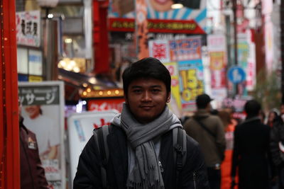 Portrait of young man standing on street in city